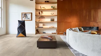 Wood Look Luxury Vinyl Plank Flooring in Modern Living Room Scene Modern living room with wood look luxury vinyl plank flooring, featuring a cozy curved sofa and contemporary decor