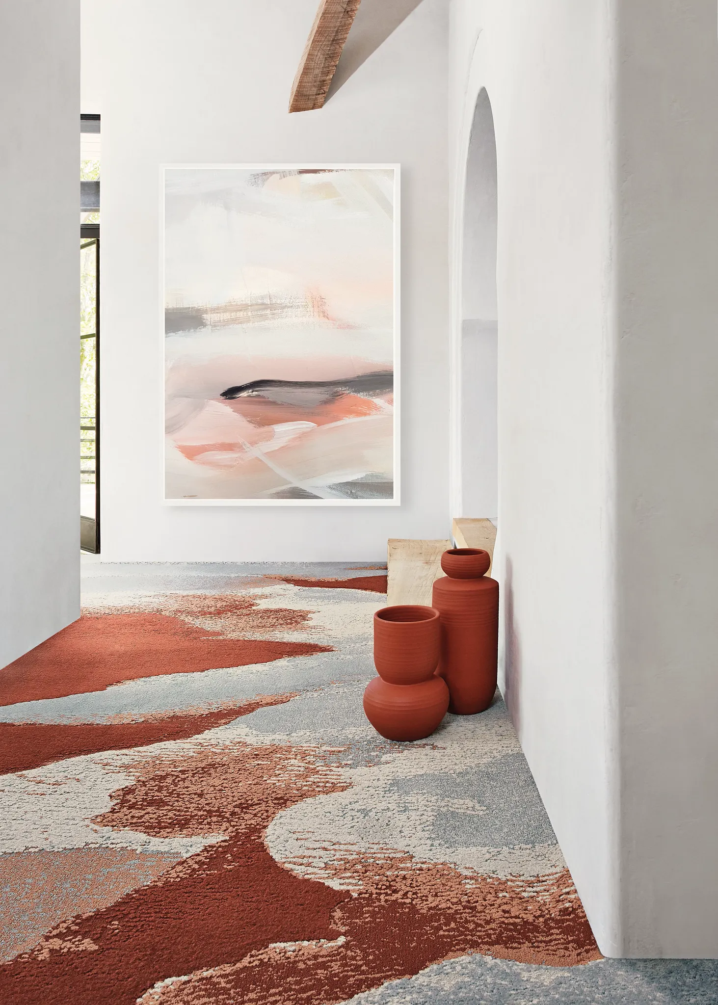 Modern hallway with abstract art and commercial carpet tile in shades of terracotta, gray, and cream