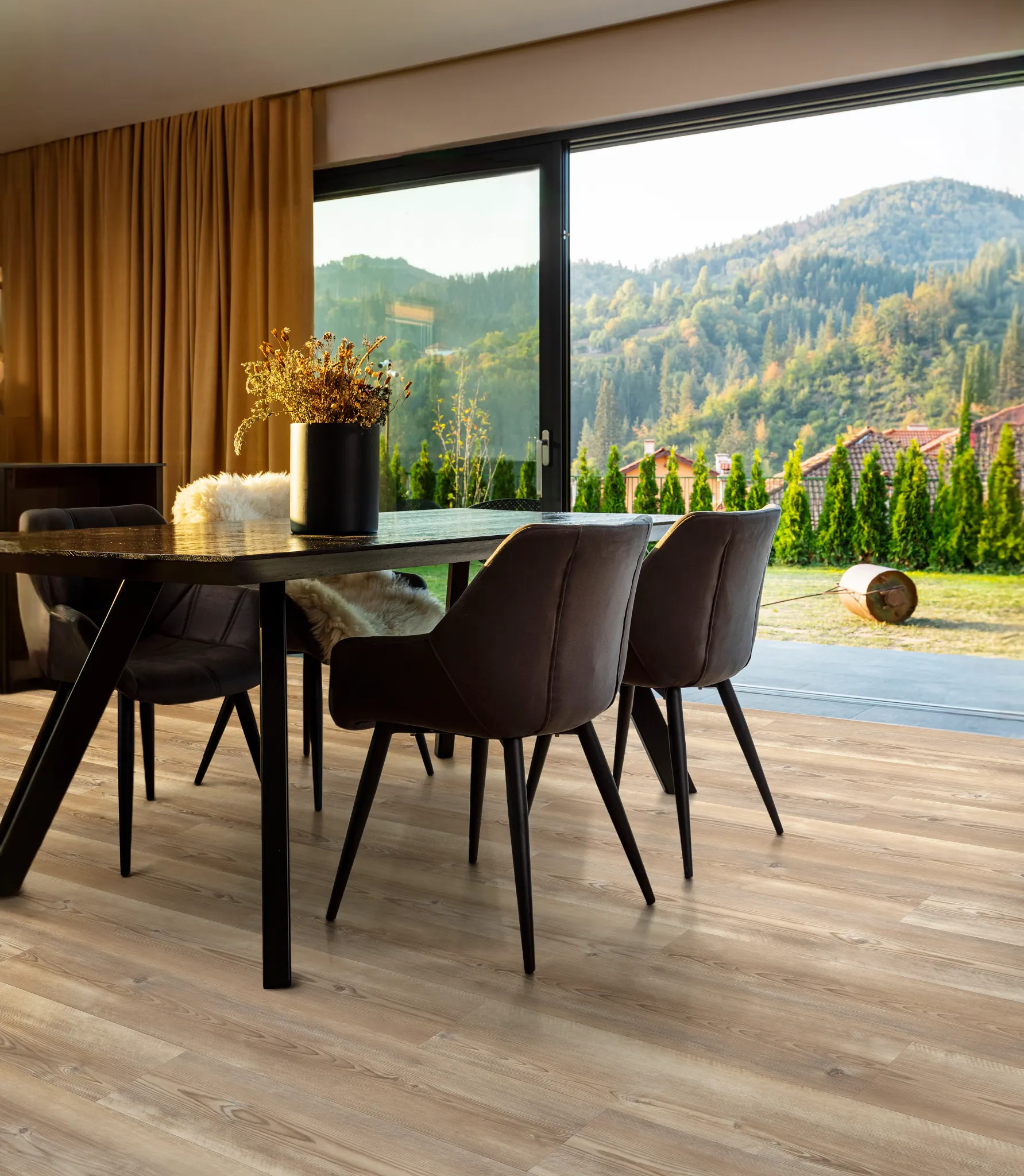Modern dining room with large windows and manufactured SPC flooring in natural wood tones