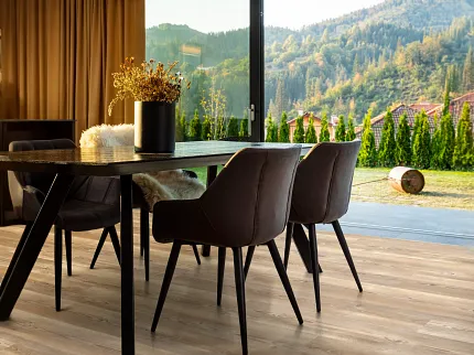 Durable SPC flooring in a cozy dining room setting with scenic views Modern dining room with large windows and manufactured SPC flooring in natural wood tones