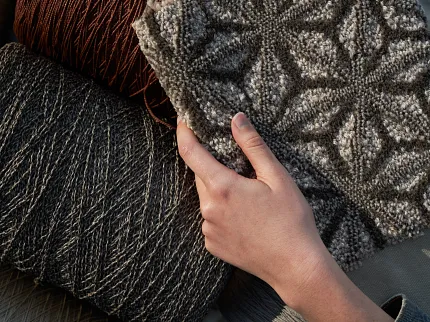 Textured Carpet Swatches in Brown and Gray - Detailed View Close-up of a person holding various carpet swatches with textured patterns in shades of brown and gray