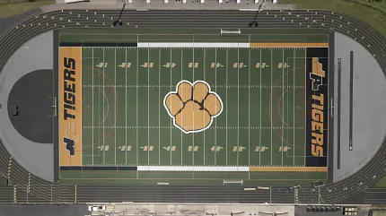 High school football field with track and tiger emblem Aerial view of a football field with tiger logo and track
