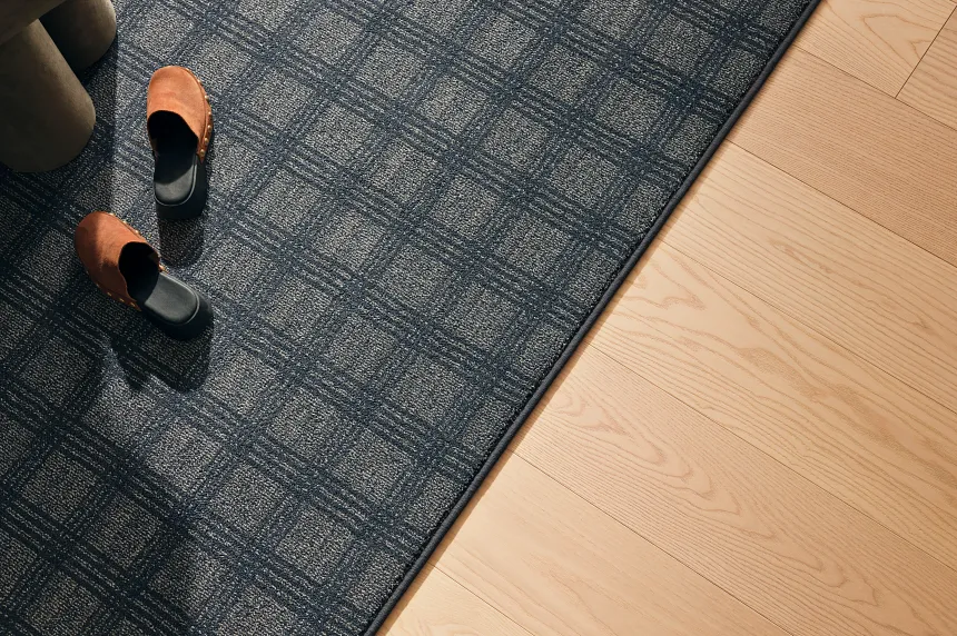 Blue Checkered Carpet and Light Hardwood Flooring Scene Blue and beige checkered carpet with light hardwood flooring and brown shoes