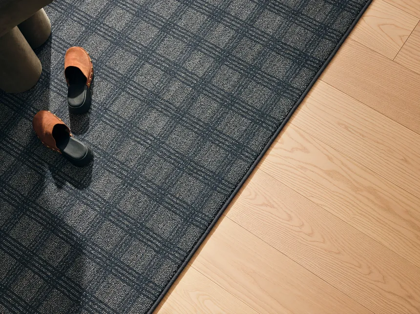 Blue Checkered Carpet and Light Hardwood Flooring Scene Blue and beige checkered carpet with light hardwood flooring and brown shoes