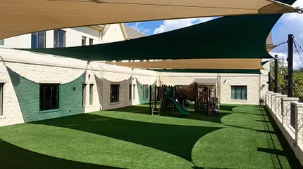 Modern playground design with synthetic turf and sun protection Outdoor playground with artificial grass and shade sails