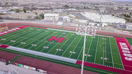 High school football field with vibrant turf design Aerial view of a football field with red and green turf