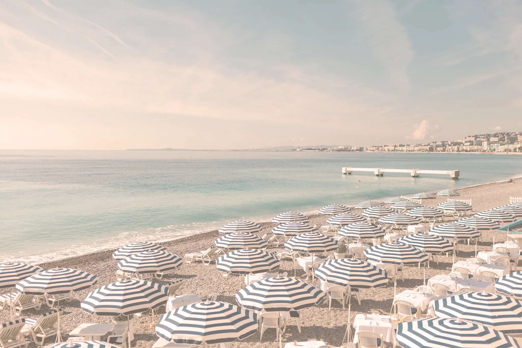 Beach scene with striped umbrellas and lounge chairs on a sunny day