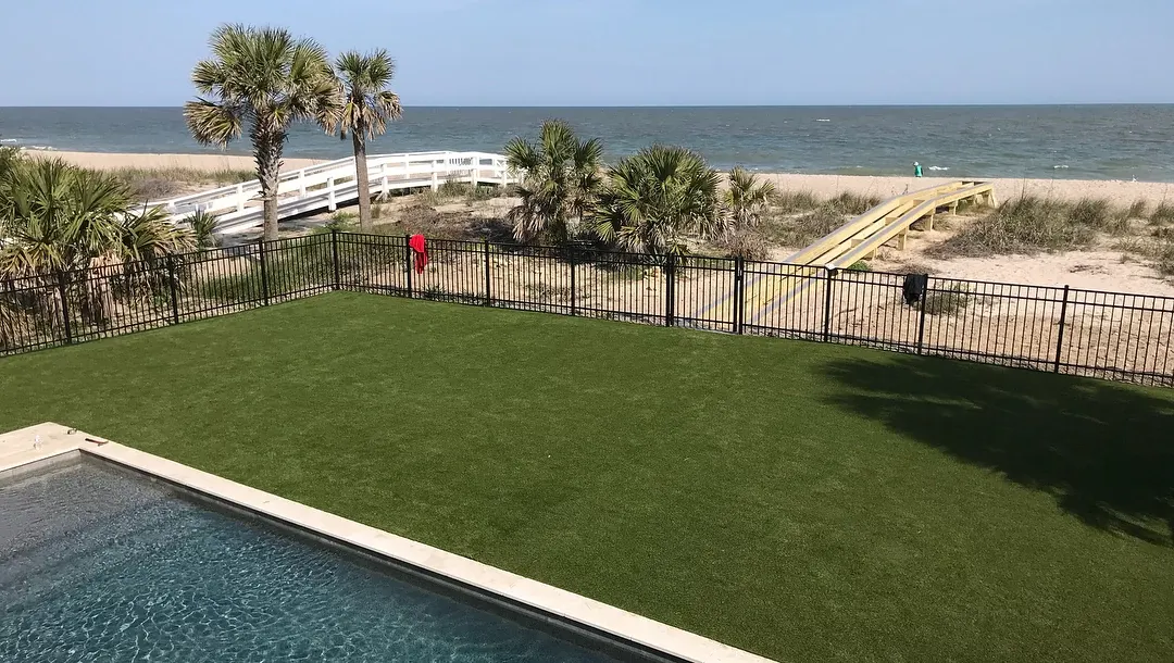Artificial grass lawn by the beach with pool view