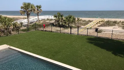 Coastal outdoor space with synthetic turf and pool Artificial grass lawn by the beach with pool view