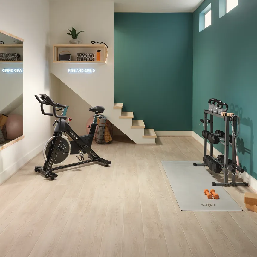 Coretec Residential SPC LVP Flooring in Home Gym - 49x7.13 inch Home gym with exercise bike and weights on Coretec Residential SPC luxury vinyl plank flooring in a wood look