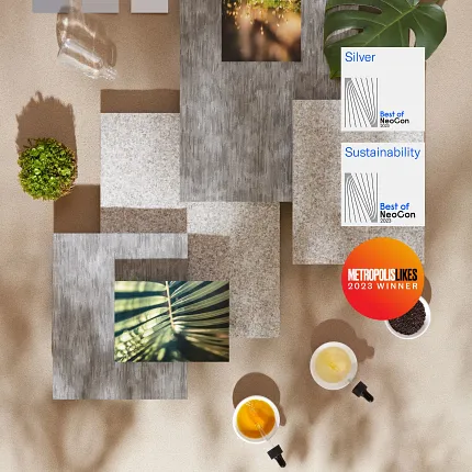 Award-winning sustainable flooring collection with neutral color swatches Overhead view of various flooring swatches in neutral tones with awards for sustainability and design excellence