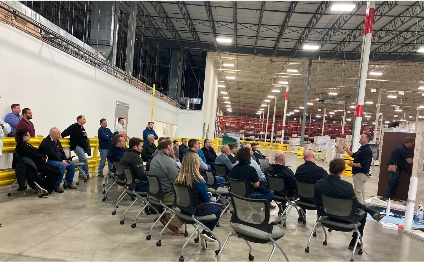 Group of customers watching an installer explain how the Shower Wall system works