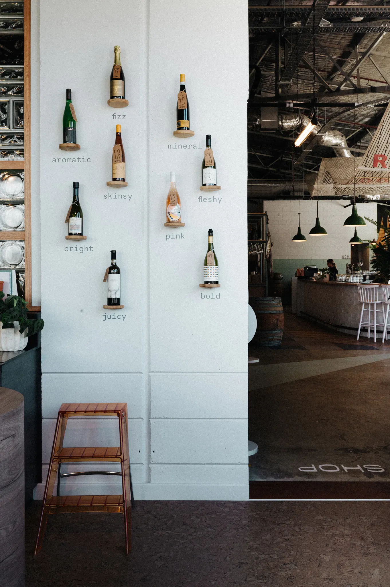 Wine bottles displayed on a wall in a modern bar setting