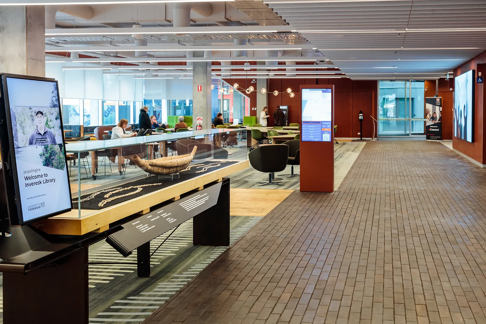 University of Tasmania library interior featuring a cultural display, custom patterned carpet flooring and collaborative learning spaces.