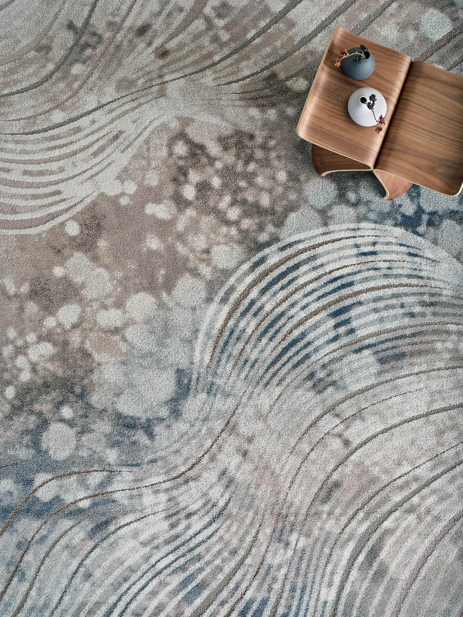 Abstract patterned carpet with neutral and blue tones