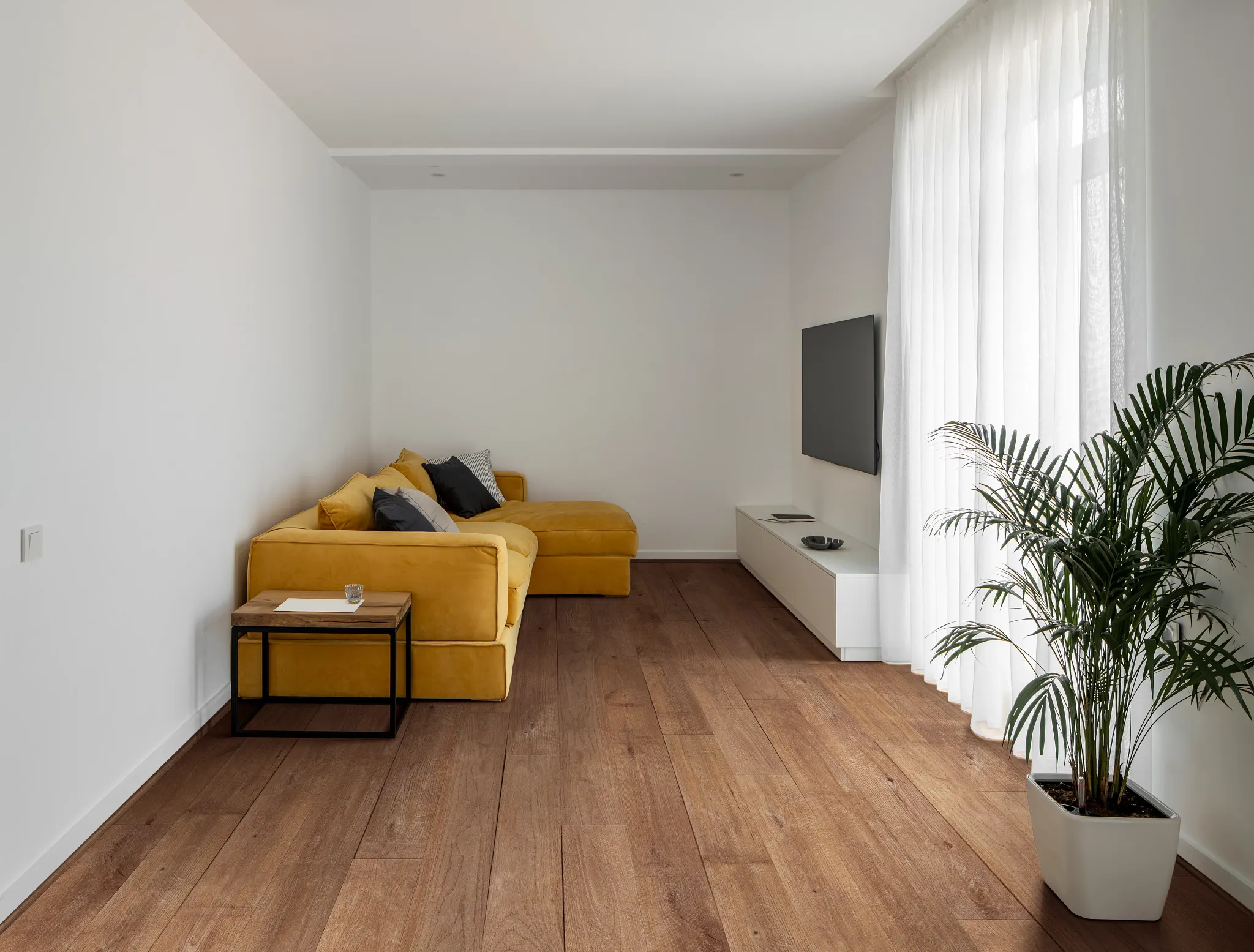 Modern living room with yellow sofa and Coretec Residential WPC luxury vinyl plank flooring in wood look