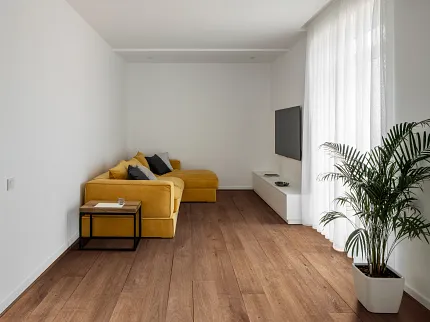 Coretec Residential WPC Luxury Vinyl Plank Flooring - 59.84x7.07 inch Wood Look Modern living room with yellow sofa and Coretec Residential WPC luxury vinyl plank flooring in wood look