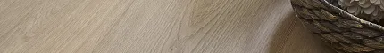 Light oak wood look luxury vinyl plank flooring with decorative vase and basket