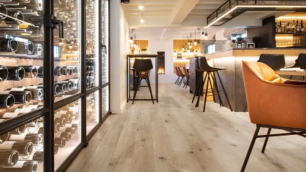 Wood Look Luxury Vinyl Plank Flooring in Modern Restaurant Interior Modern restaurant interior with wood look luxury vinyl plank flooring, featuring a wine display and stylish seating.