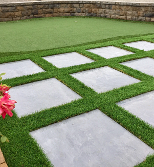 Turf installed in a backyard with large marble squares