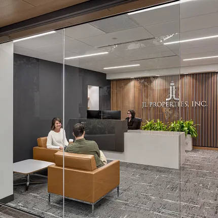 Contemporary Office Reception with Commercial Carpet Tile Flooring Modern office reception area with commercial carpet tile flooring, featuring a glass wall, wooden slat accent wall, and contemporary seating.