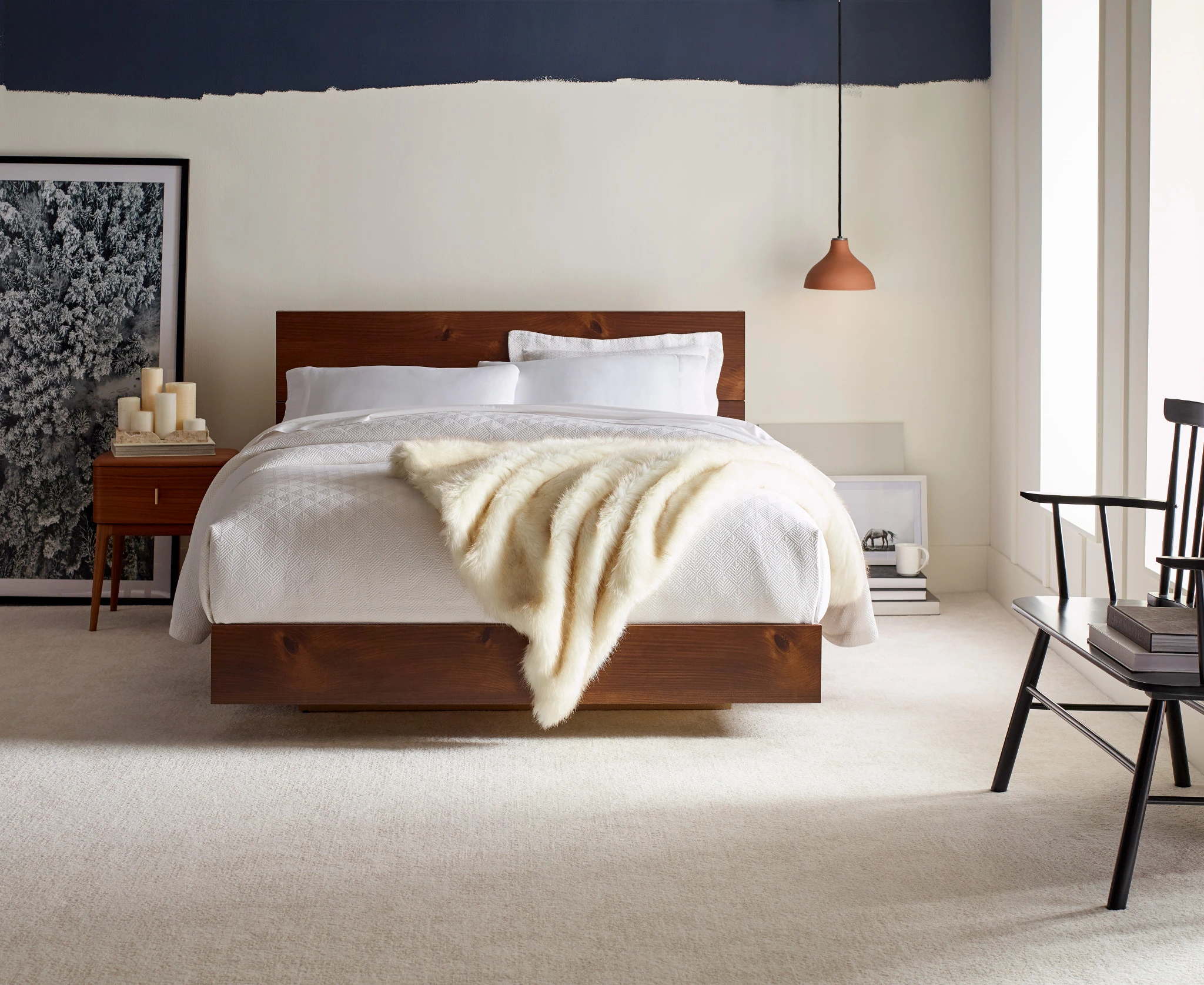 Modern bedroom with a wooden bed frame, white bedding, and a soft beige carpet flooring