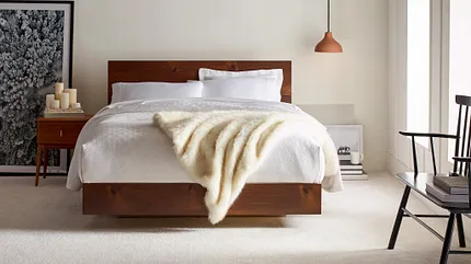 Contemporary bedroom design with beige carpet flooring and wooden furniture Modern bedroom with a wooden bed frame, white bedding, and a soft beige carpet flooring
