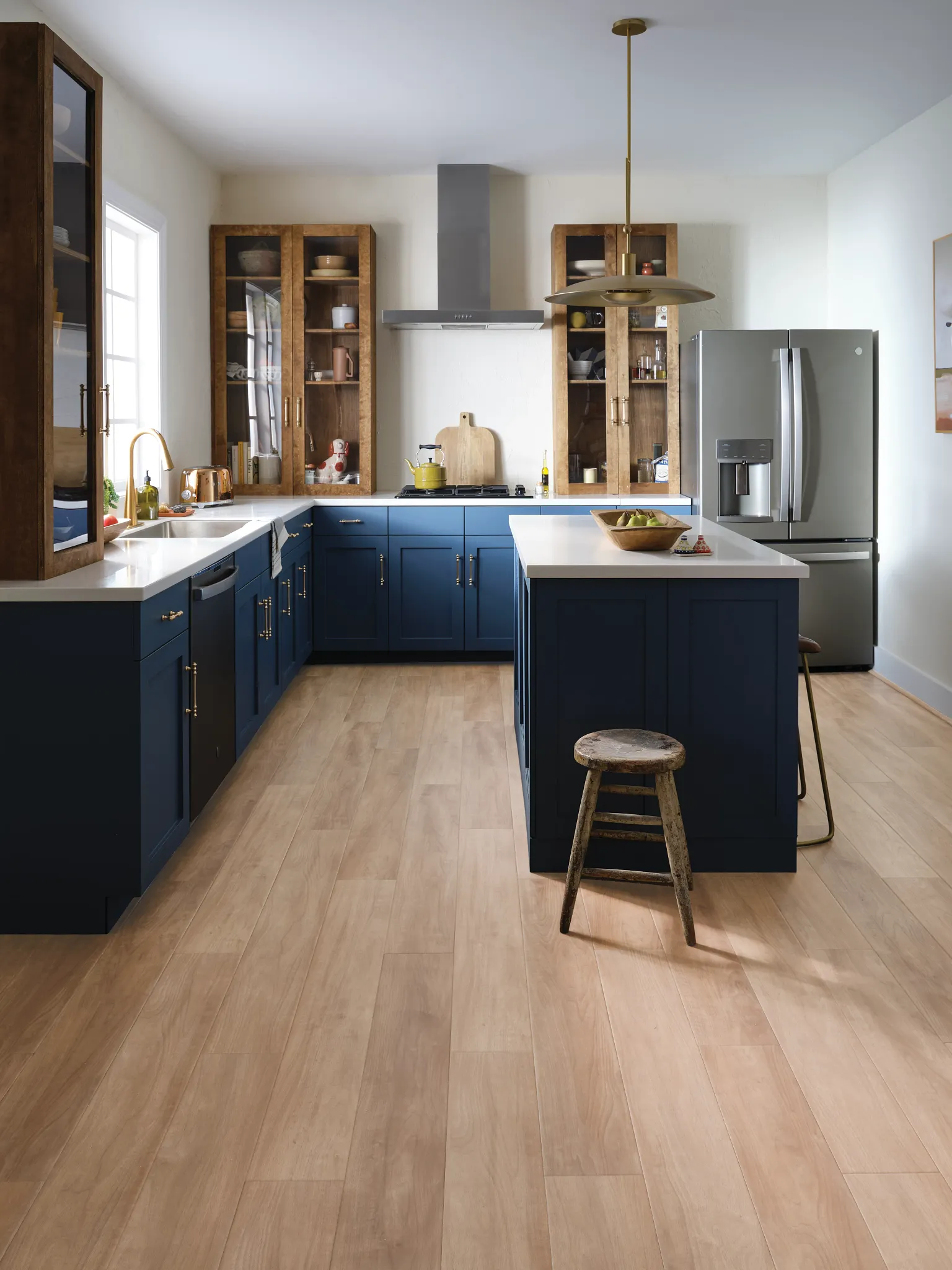 kitchen with luxury vinyl plank floor in a light wood look with blue cabinets and stainless steel appliances