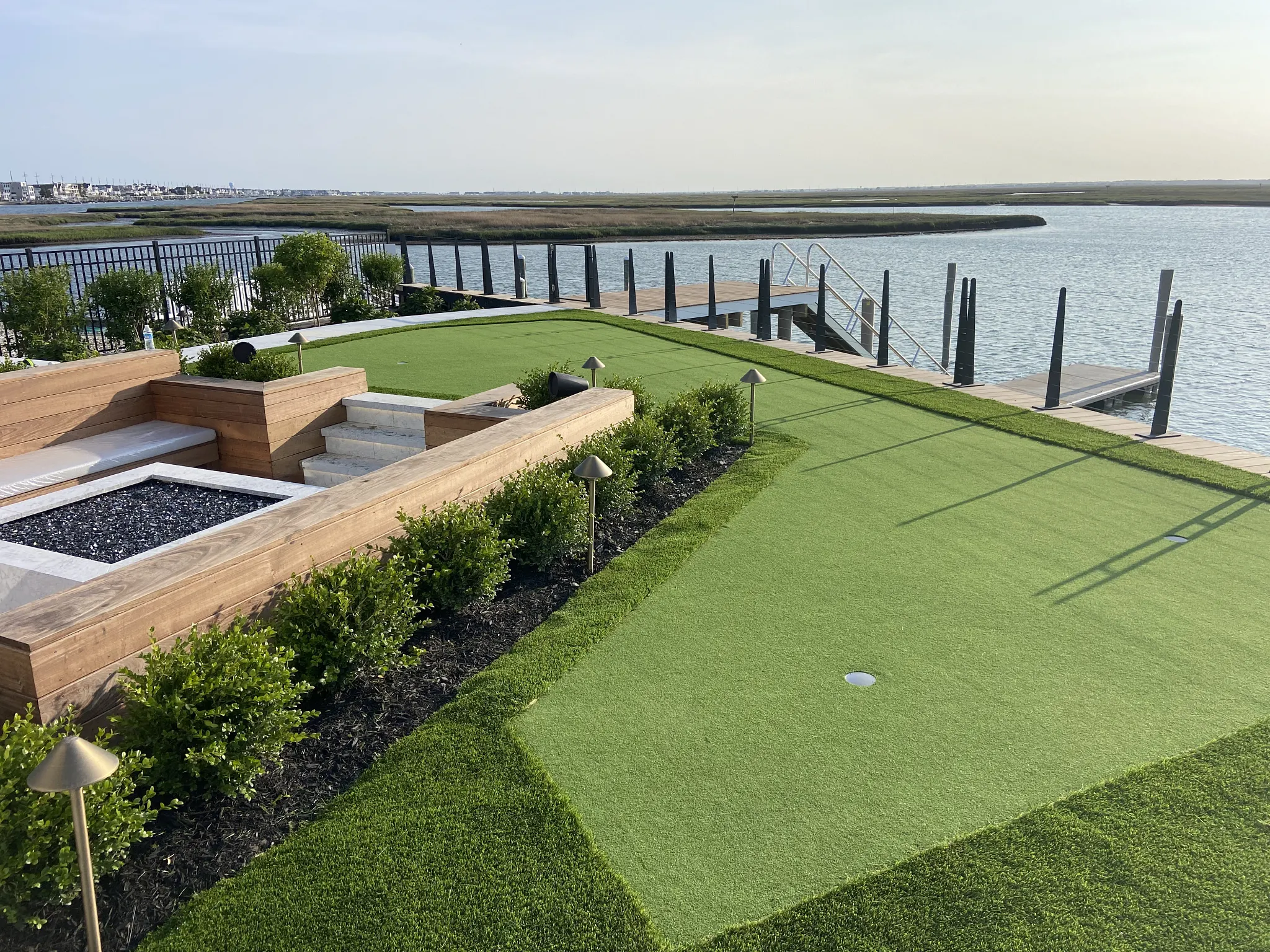 Backyard putting green overlooking waterfront dock and marsh landscape