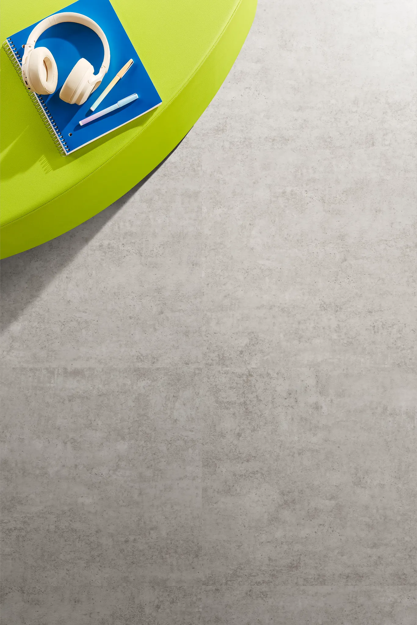 Heavy commercial luxury vinyl tile flooring with notebook and headphones on green surface