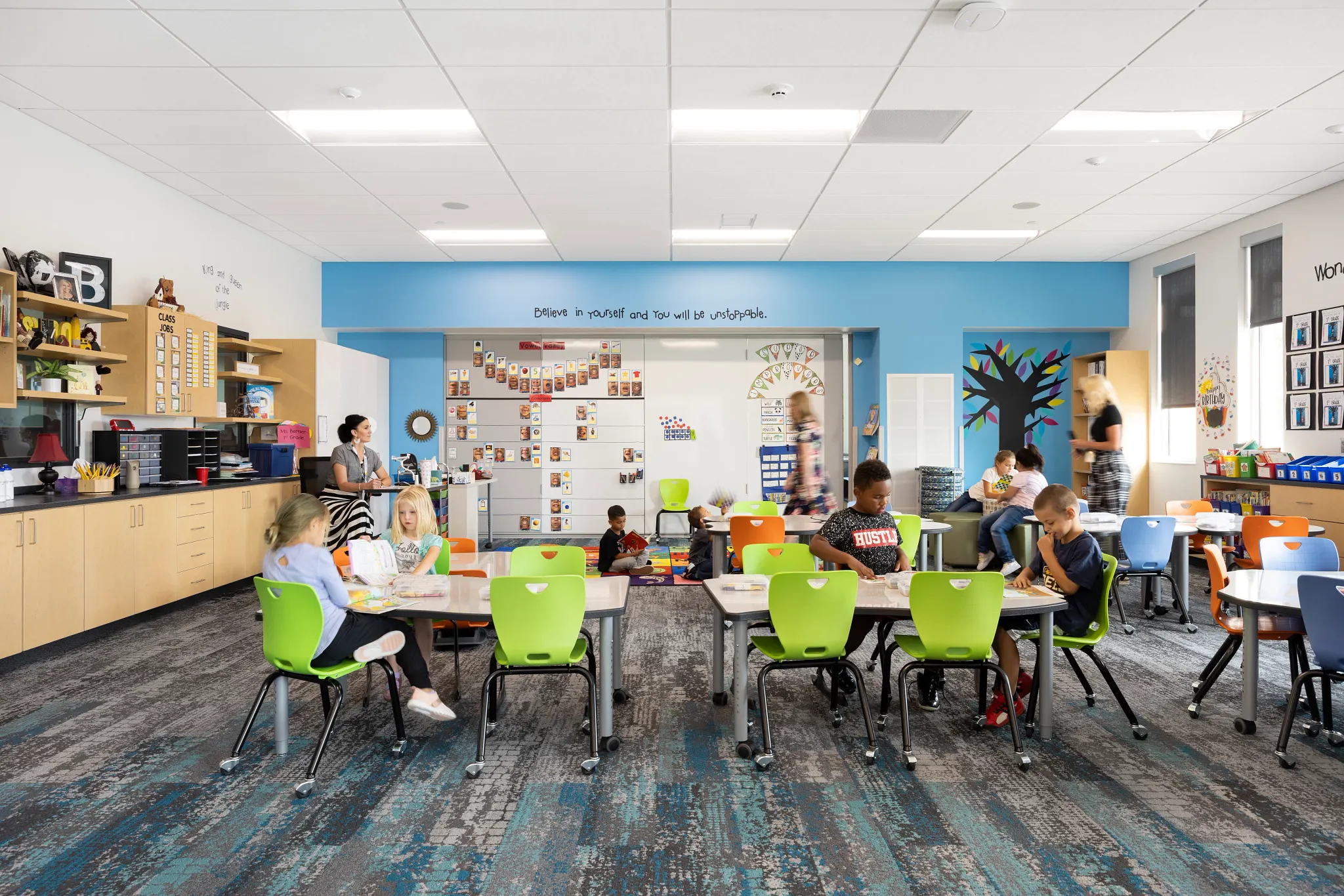 Classroom with colorful chairs and educational decor featuring Commercial Carpet Tile flooring in a K-12 Education Facility