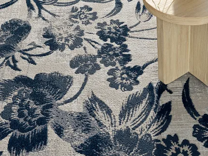 Stylish floral carpet design for modern interiors Floral patterned carpet in navy and beige with wooden table and white flowers