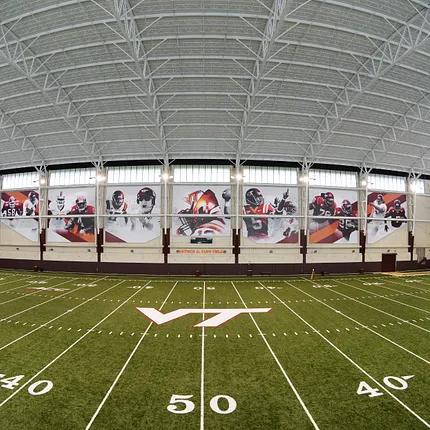 Indoor Sports Facility with Artificial Turf Field and Wall Banners Indoor sports facility with artificial turf field and large sports-themed wall banners