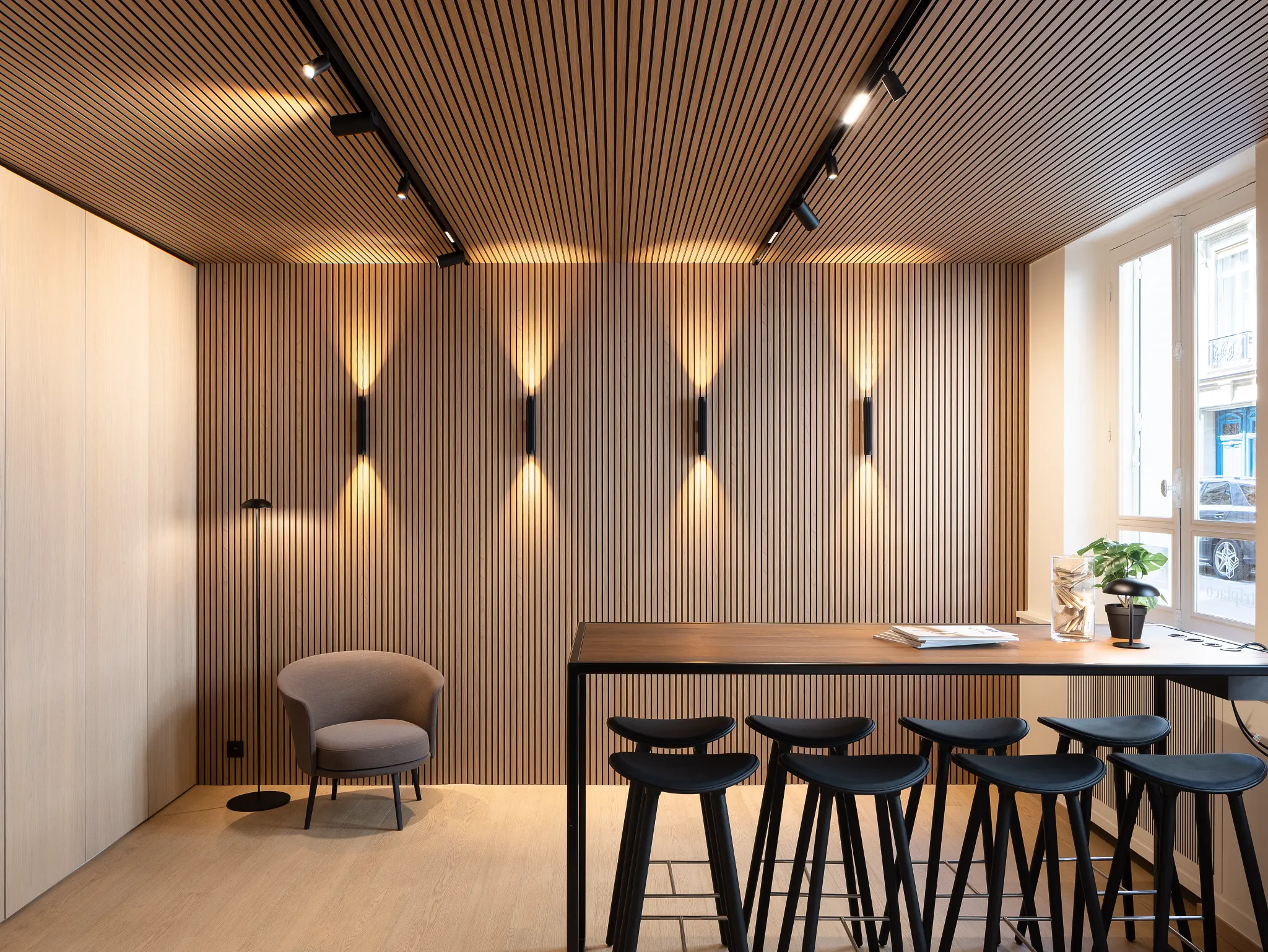 Modern dining area with wood-look luxury vinyl flooring and sleek black bar stools