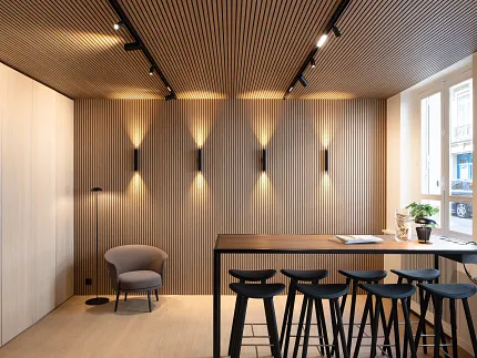 Contemporary dining room with wood-look vinyl flooring and stylish seating Modern dining area with wood-look luxury vinyl flooring and sleek black bar stools