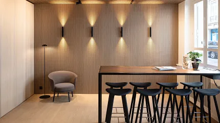Contemporary dining room with wood-look vinyl flooring and stylish seating Modern dining area with wood-look luxury vinyl flooring and sleek black bar stools