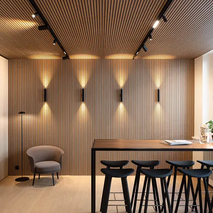 Contemporary dining room with wood-look vinyl flooring and stylish seating Modern dining area with wood-look luxury vinyl flooring and sleek black bar stools