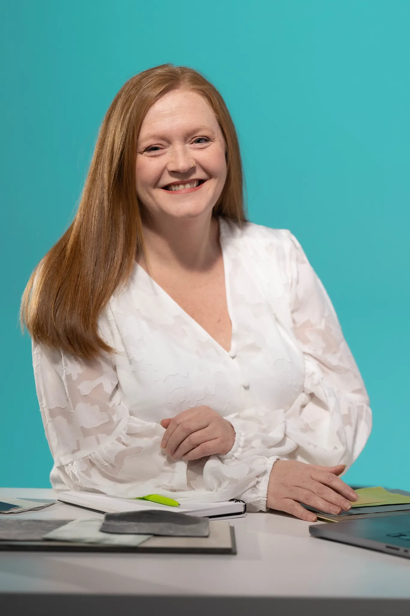A business style headshot of a woman with red hair and a white shirt