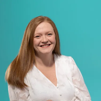 A business style headshot of a woman with red hair and a white shirt