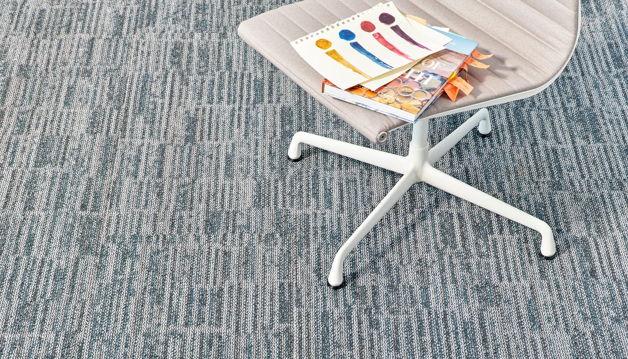 Modern carpet tile in blue and gray pattern with a chair and color swatches