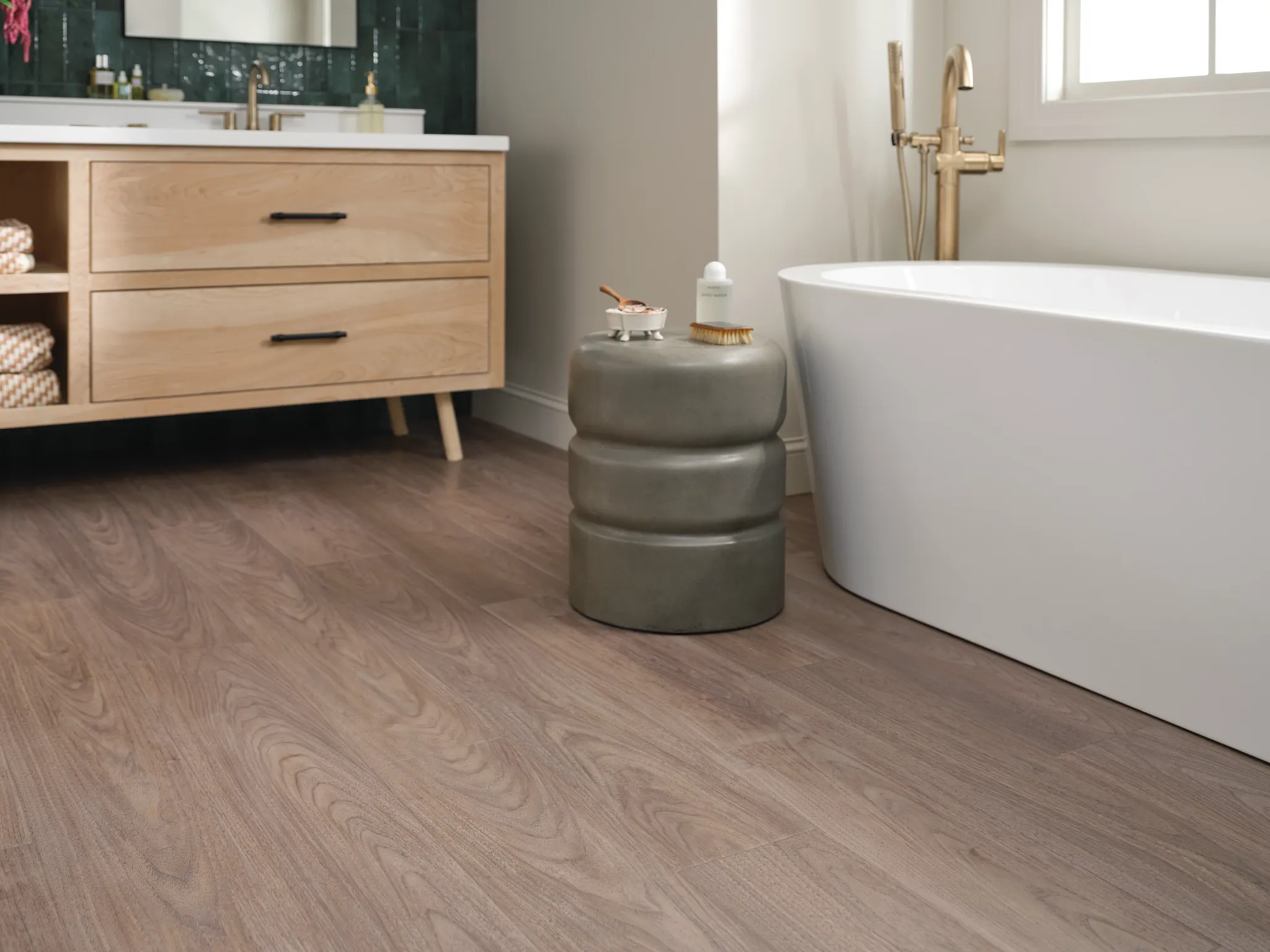Modern bathroom with light wood flooring, featuring a freestanding bathtub and wooden vanity