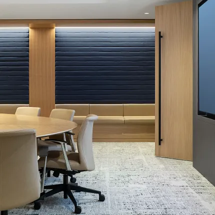 Modern conference room with beige chairs and a round table on a commercial broadloom carpet