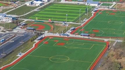 Sports complex with artificial turf fields and tracks Aerial view of sports complex with multiple artificial turf fields and running tracks