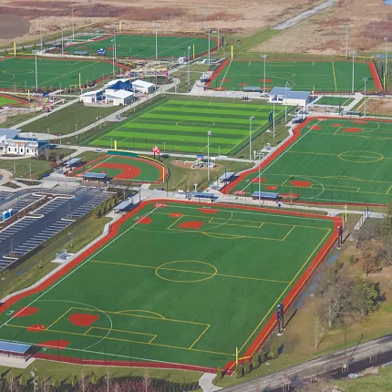 Sports complex with artificial turf fields and tracks Aerial view of sports complex with multiple artificial turf fields and running tracks