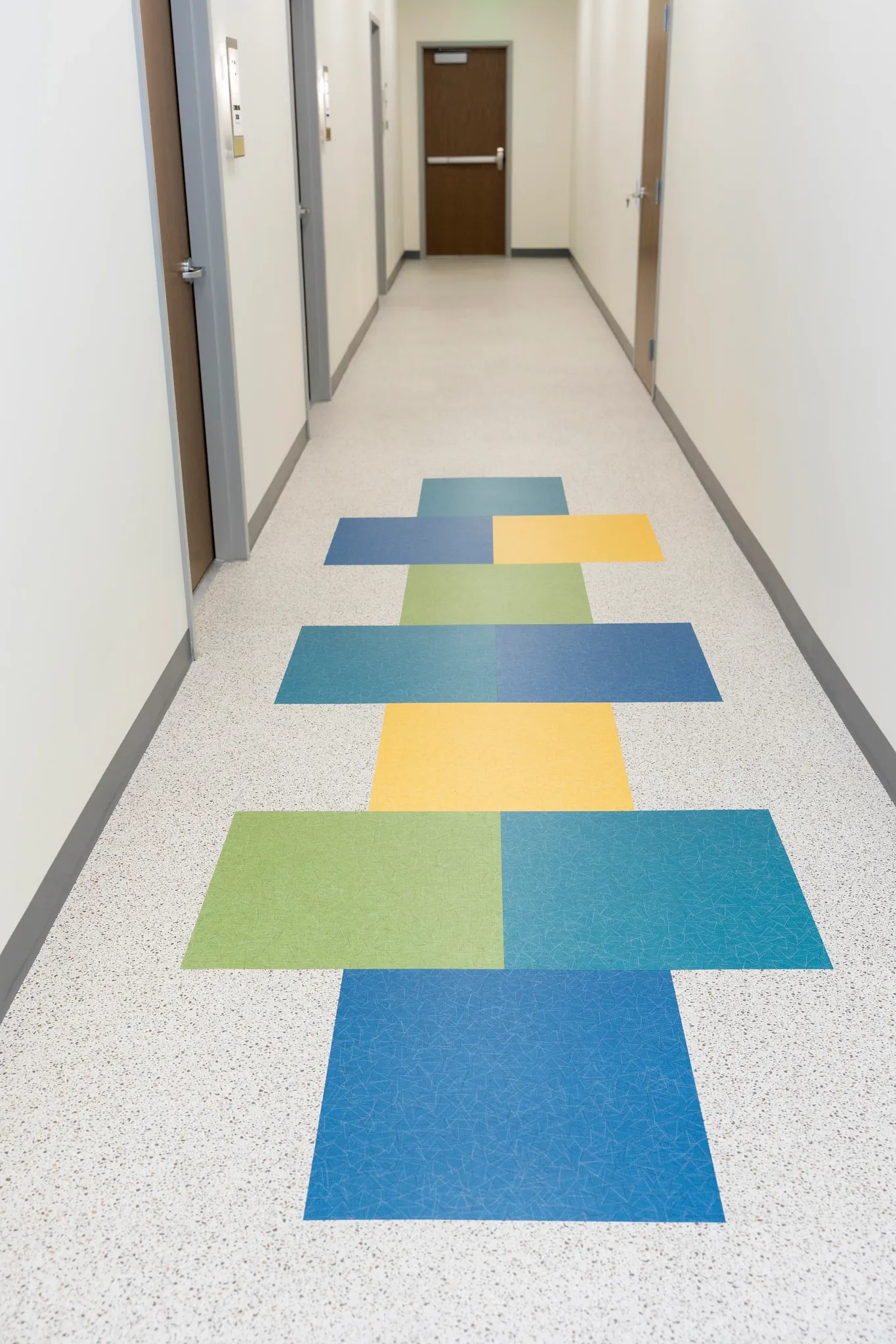 Grace Counseling Center LVT tile in blue, green, and yellow in a hallway