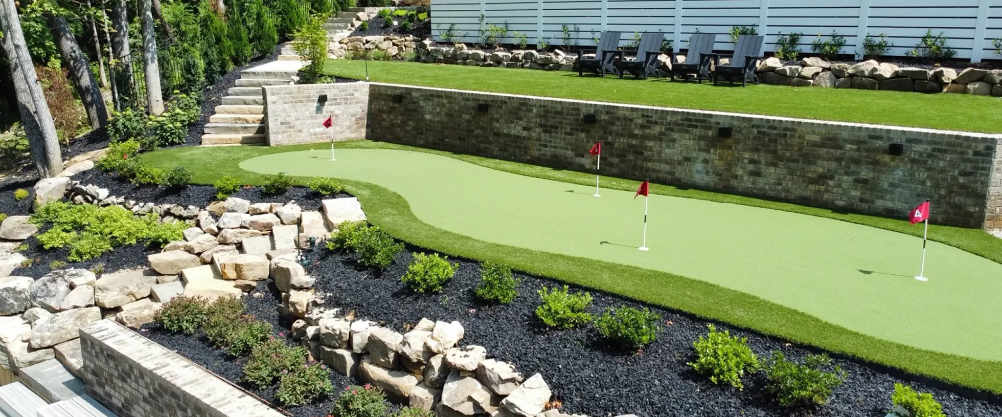 Outdoor putting green with landscaping and seating area