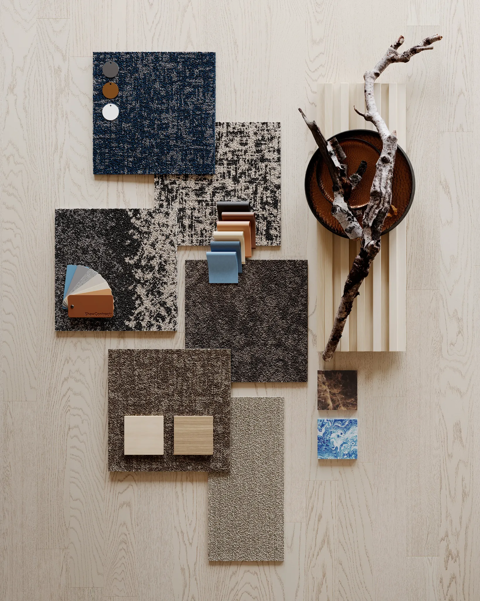 Assorted commercial carpet tile swatches in blue, gray, and brown tones on a light wood surface