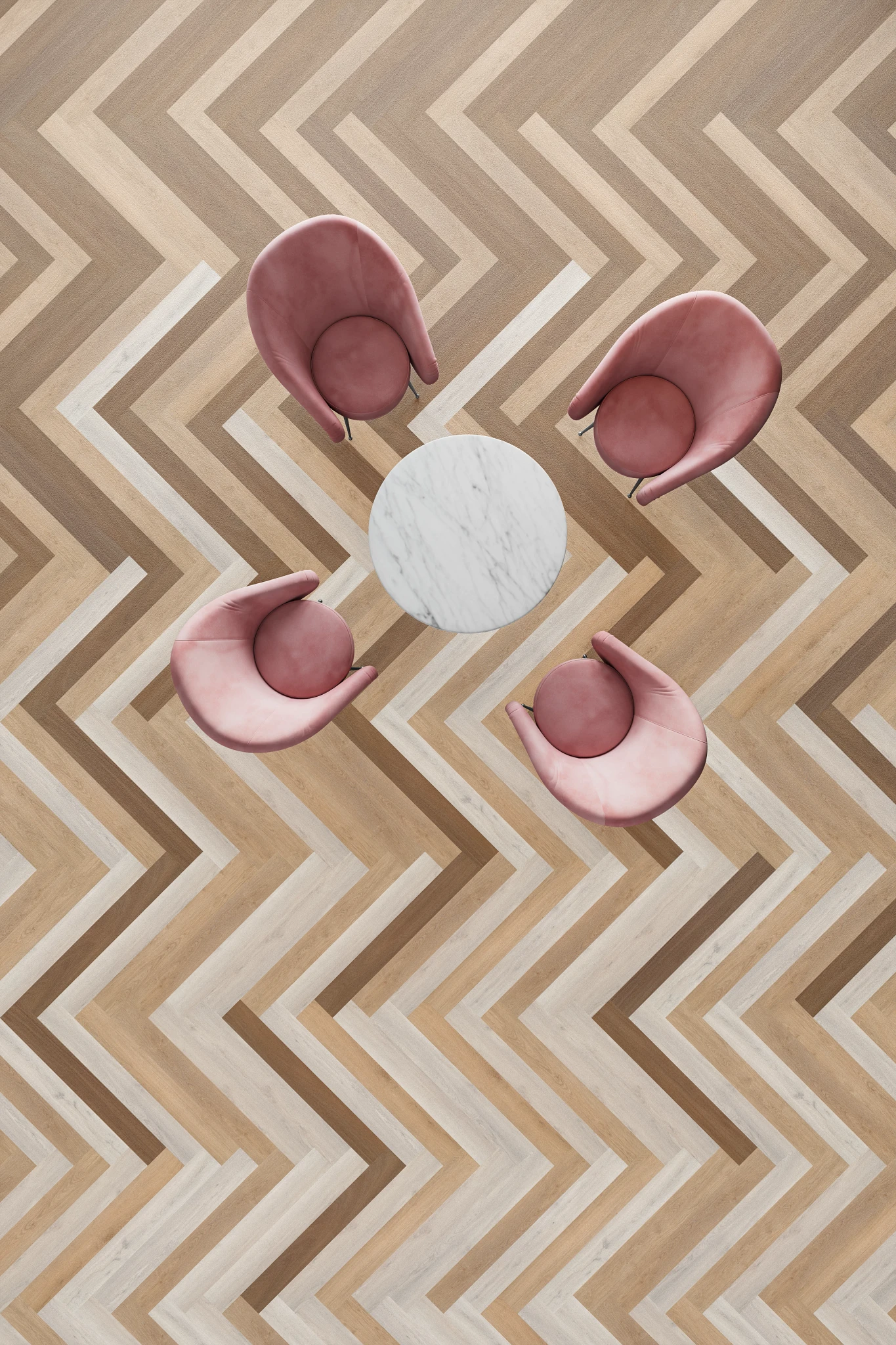 Overhead view of a hospitality setting featuring a chevron-patterned flooring in shades of light and dark brown with pink chairs and a round marble table