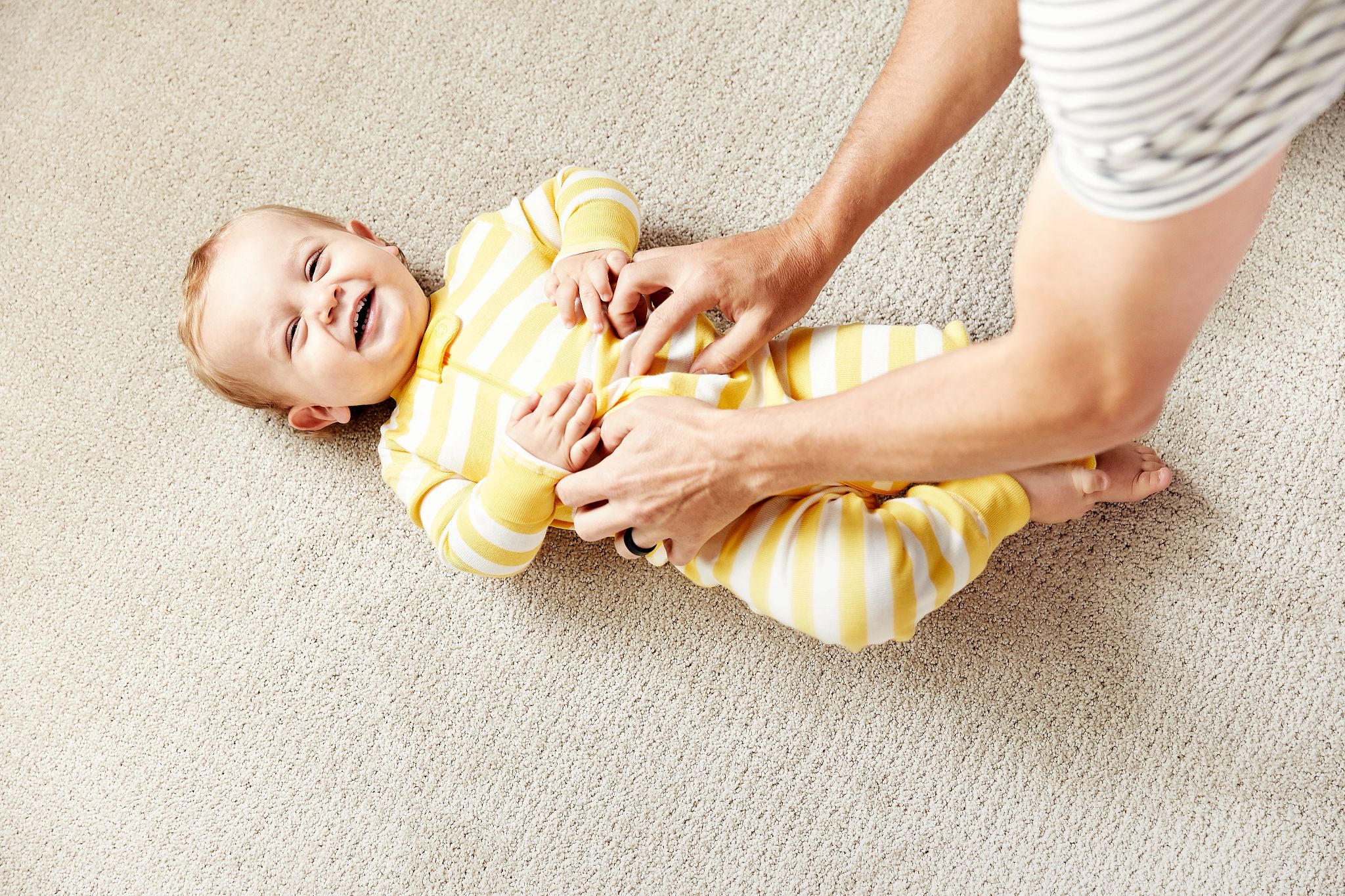 Image of happy baby lounging on carpet style Translate in color Biscuit.tif