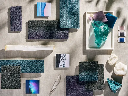 Carpet Swatch Collection with Natural Elements and Fabric Samples Assorted carpet swatches in shades of blue, purple, and black with natural elements and fabric samples on a textured surface